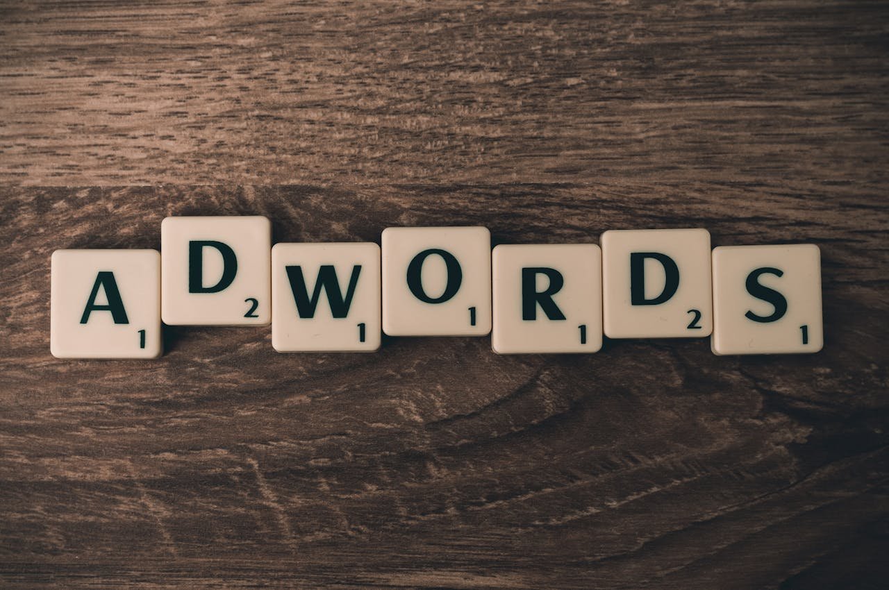 brand-03 Scrabble tiles spelling AdWords on a wooden surface, symbolizing digital marketing concepts.